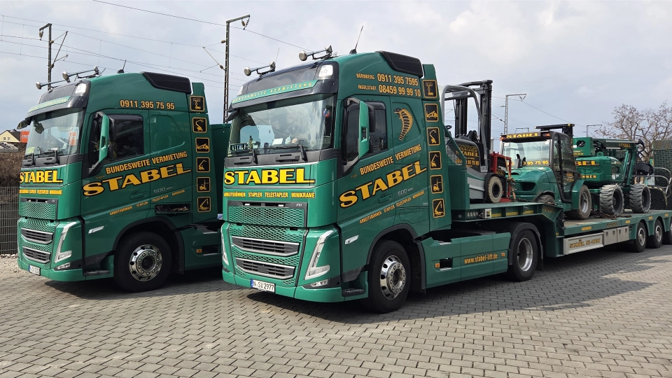 Eigene Logistik-LKW von Arbeitsbühnen Stabel beladen mit Teleskopstapler und Gelenkteleskopbühne für den Einsatz in München.